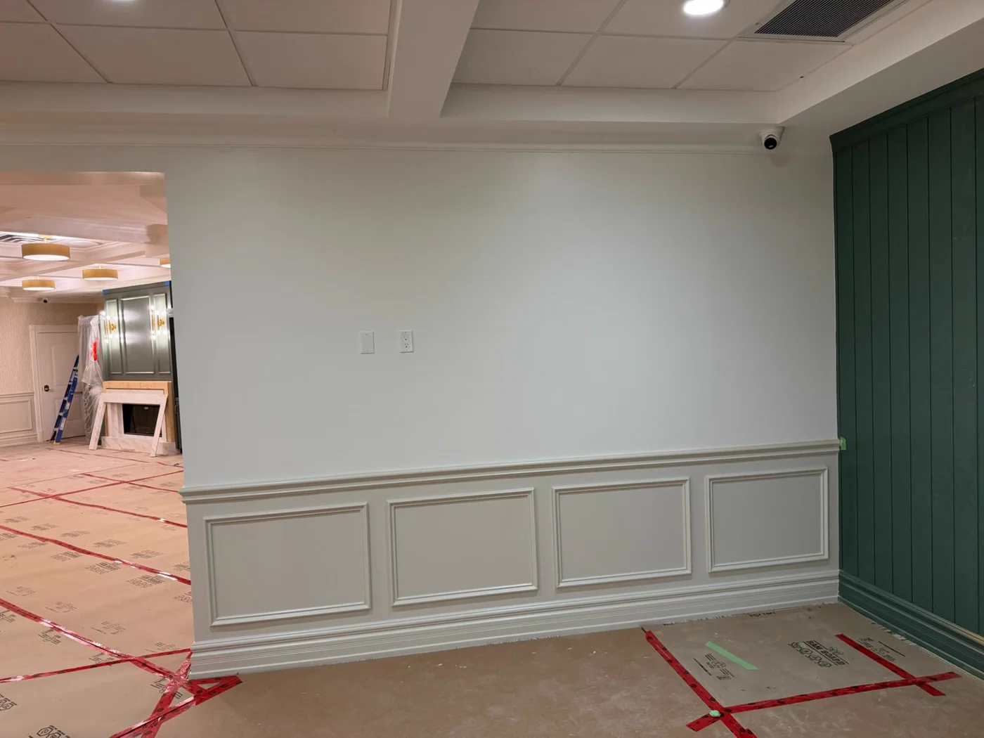 Sage-green panel wall with white wainscoting